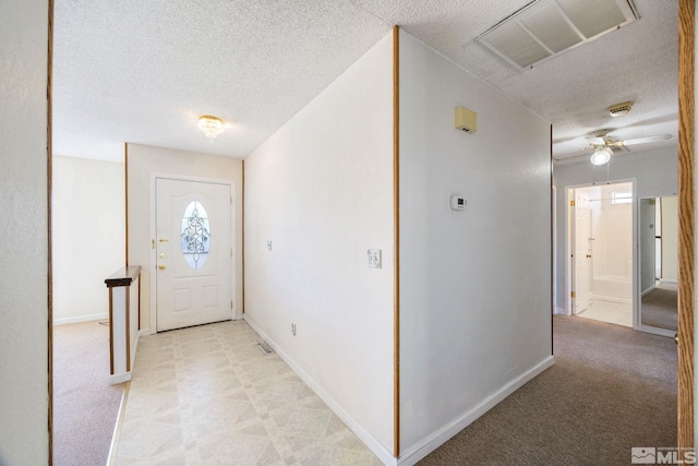 foyer with a textured ceiling, baseboards, and ceiling fan