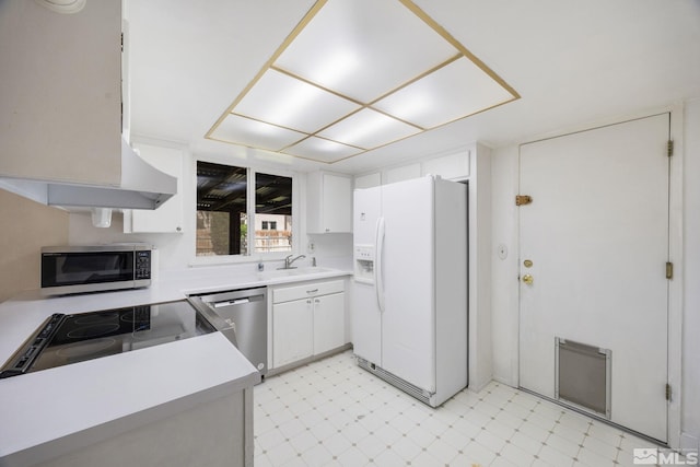 kitchen with appliances with stainless steel finishes, light flooring, a sink, and light countertops