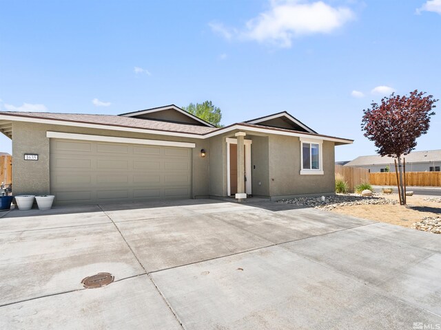 single story home featuring concrete driveway, stucco siding, fence, and a garage