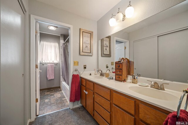 bathroom with shower / tub combo, double vanity, and stone finish floors