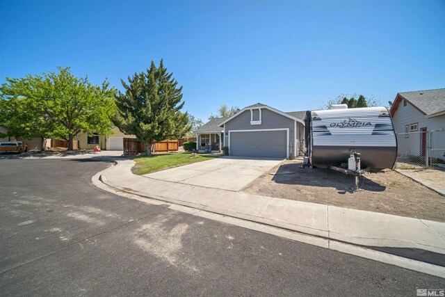view of front of house with driveway, a garage, and fence