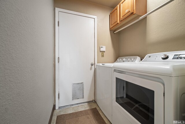 laundry area featuring cabinet space, washing machine and clothes dryer, and a textured wall