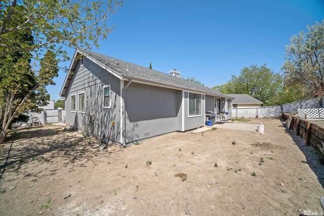 rear view of house featuring a fenced backyard and a patio