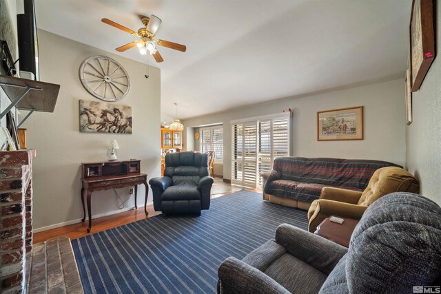 living area featuring ceiling fan, wood finished floors, vaulted ceiling, and baseboards