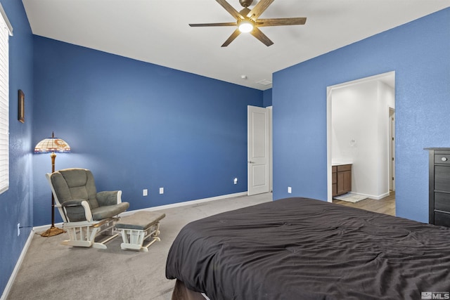 bedroom featuring baseboards, ensuite bathroom, and a ceiling fan