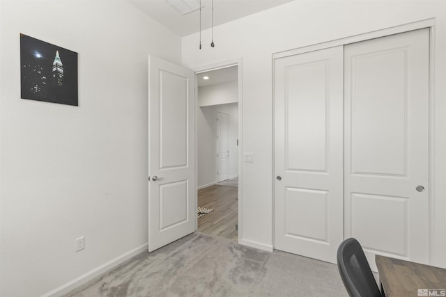 unfurnished office featuring baseboards and light carpet
