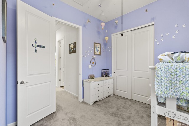 bedroom featuring light colored carpet and a closet