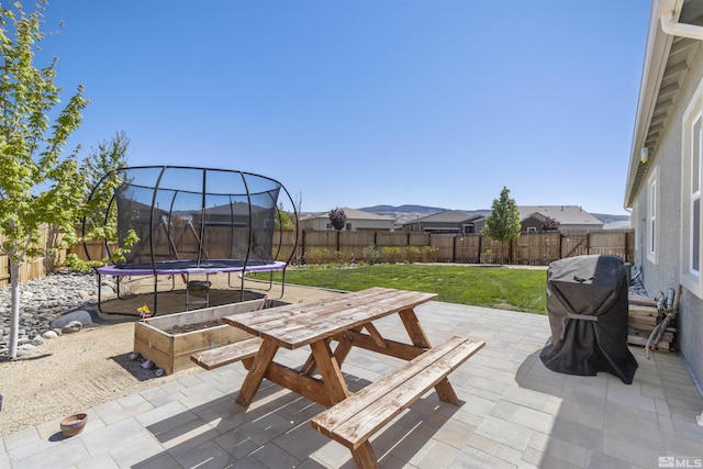 view of patio / terrace featuring a trampoline, outdoor dining area, and grilling area