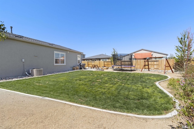 view of yard featuring a trampoline, a playground, a patio area, and central air condition unit