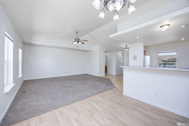 unfurnished living room with baseboards, a ceiling fan, light wood finished floors, vaulted ceiling, and recessed lighting