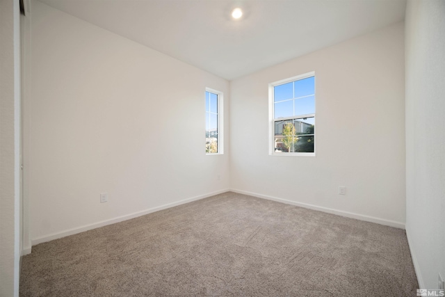 unfurnished room featuring carpet floors and baseboards