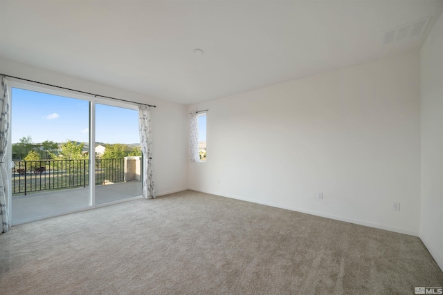 carpeted spare room featuring baseboards