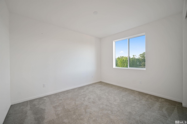 unfurnished room featuring carpet floors and baseboards