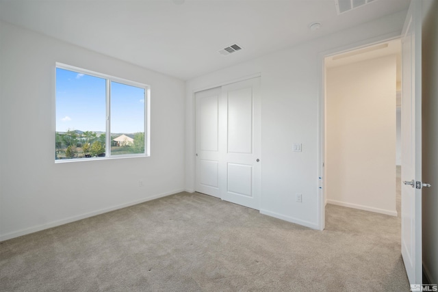 unfurnished bedroom featuring carpet, baseboards, and a closet