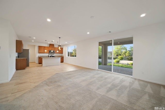 unfurnished living room featuring recessed lighting and baseboards