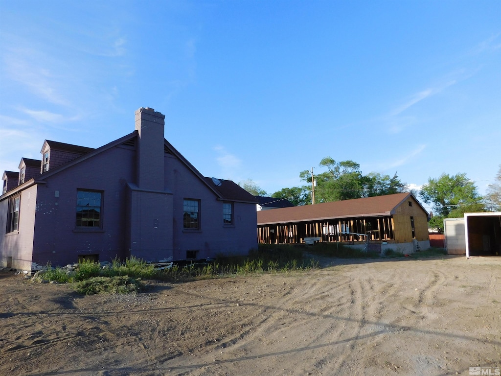 back of house with a chimney