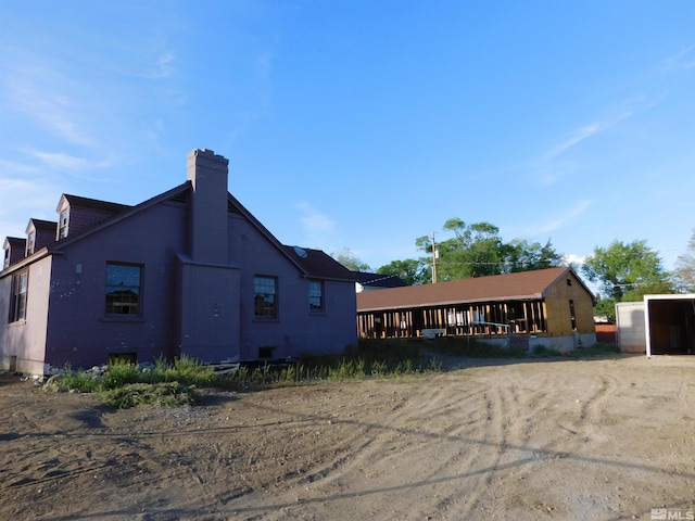 back of house with a chimney