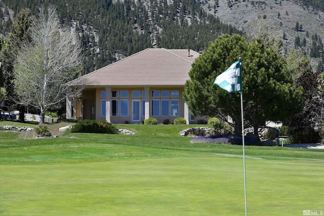 surrounding community with a lawn, a mountain view, and view of golf course