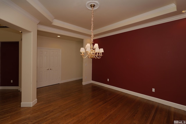unfurnished dining area featuring a tray ceiling, a chandelier, dark wood-style floors, baseboards, and ornamental molding