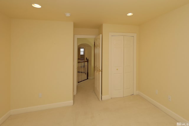 unfurnished room with light carpet, recessed lighting, baseboards, arched walkways, and a smoke detector