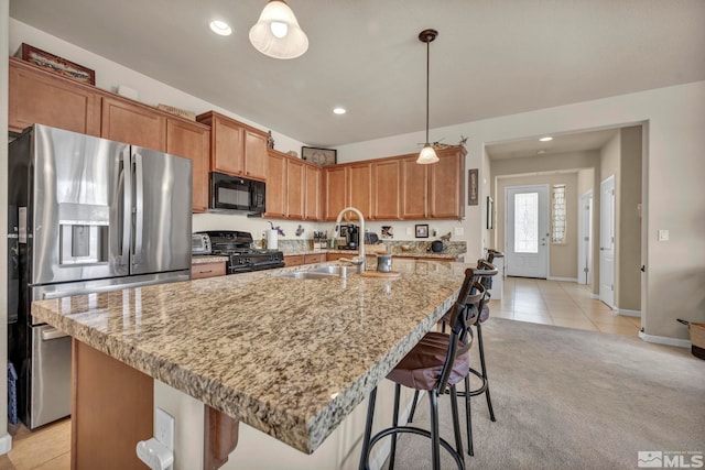 kitchen with black appliances, a sink, baseboards, light stone counters, and recessed lighting