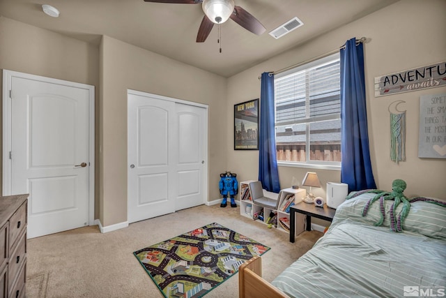 bedroom featuring light carpet, a closet, a ceiling fan, and baseboards