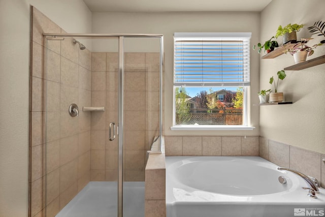 bathroom with a shower stall and a bath