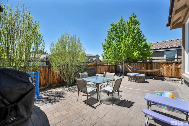 view of patio / terrace with an outdoor fire pit, a fenced backyard, and outdoor dining area