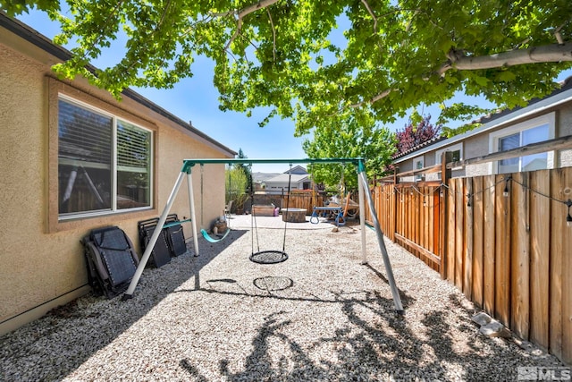 fenced backyard featuring a patio and a playground