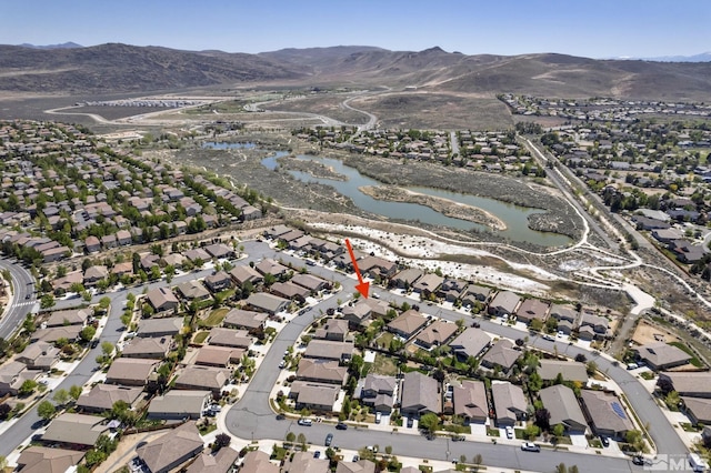 aerial overview of property's location with a water and mountain view and nearby suburban area