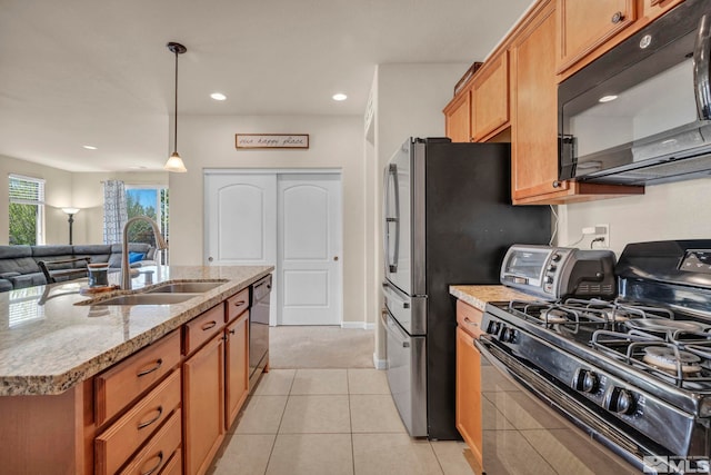 kitchen featuring black appliances, a sink, open floor plan, recessed lighting, and light stone countertops