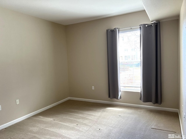 carpeted spare room with baseboards