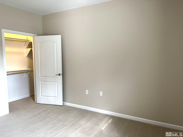 unfurnished bedroom with carpet flooring, baseboards, and a closet