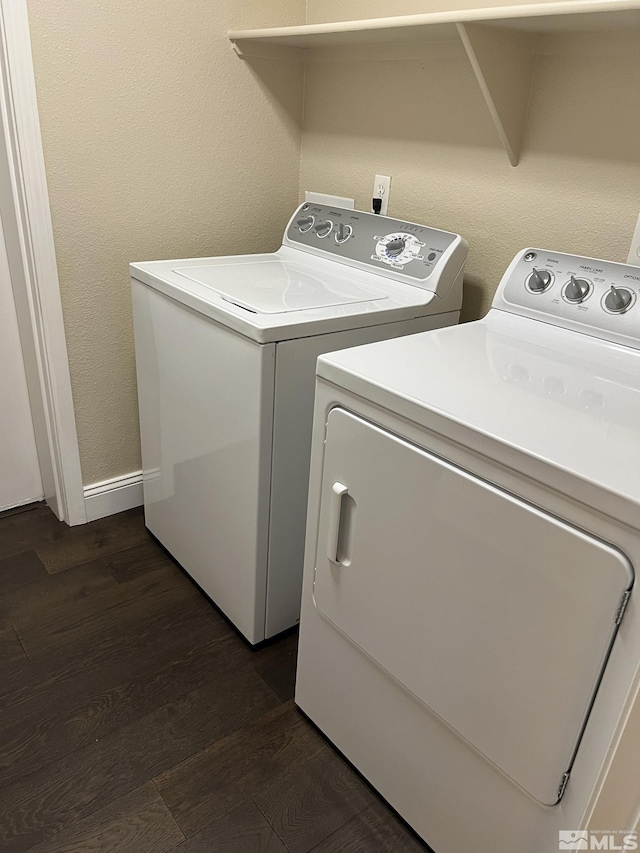 laundry room featuring washing machine and dryer, dark wood-type flooring, and baseboards
