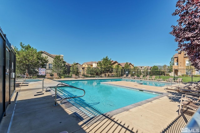 community pool featuring fence and a patio