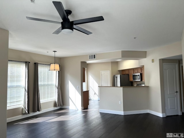 unfurnished living room featuring dark wood finished floors, ceiling fan, and baseboards
