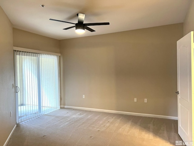 empty room featuring light colored carpet, ceiling fan, baseboards, fire sprinkler in ceiling, and plenty of natural light