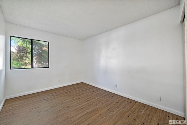 unfurnished room featuring wood finished floors and baseboards