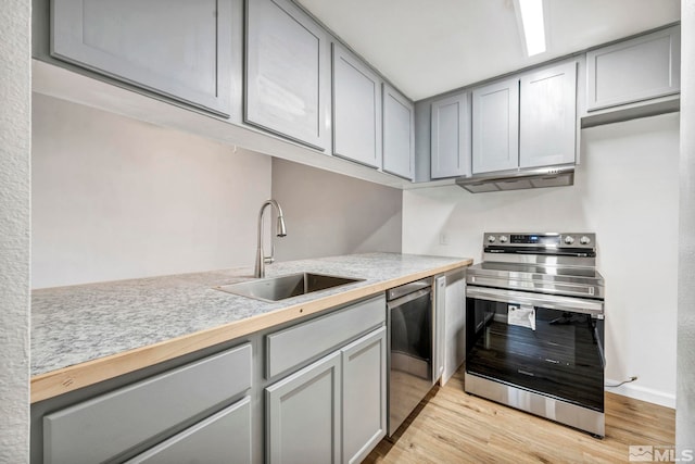 kitchen with stainless steel appliances, gray cabinets, a sink, and light countertops