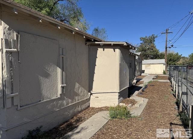 view of side of home featuring fence