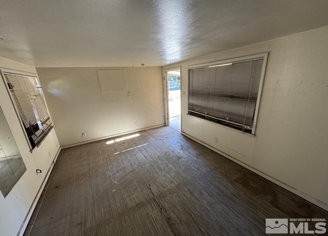 unfurnished living room with wood finished floors and baseboards