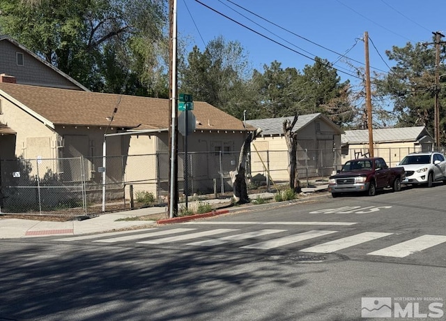 view of asphalt road with curbs and sidewalks