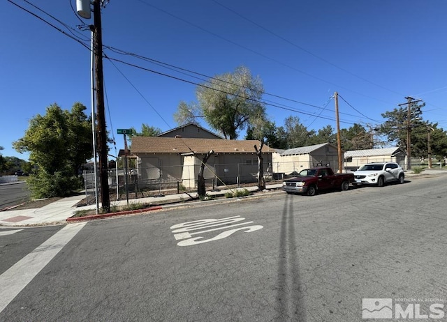 view of asphalt road featuring sidewalks and curbs
