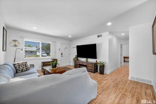 living room with light wood finished floors, baseboards, and recessed lighting