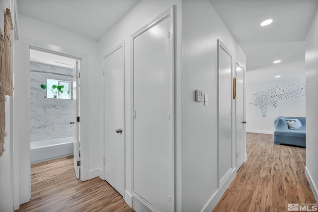 corridor with light wood-type flooring, recessed lighting, and baseboards