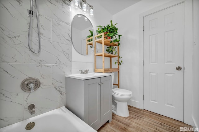 full bath featuring vanity, wood finished floors, toilet, and shower / washtub combination
