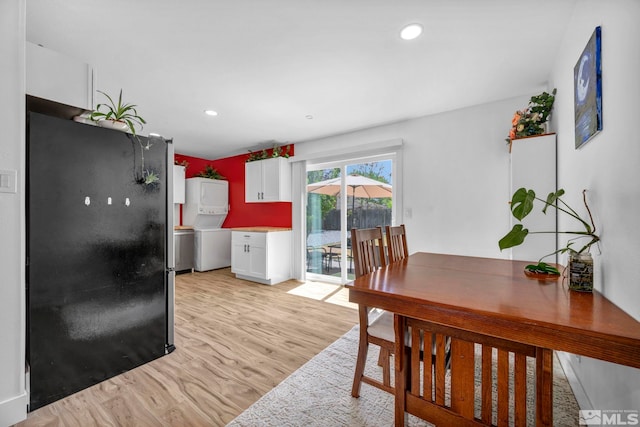 dining area featuring stacked washer / dryer, light wood-style flooring, and recessed lighting