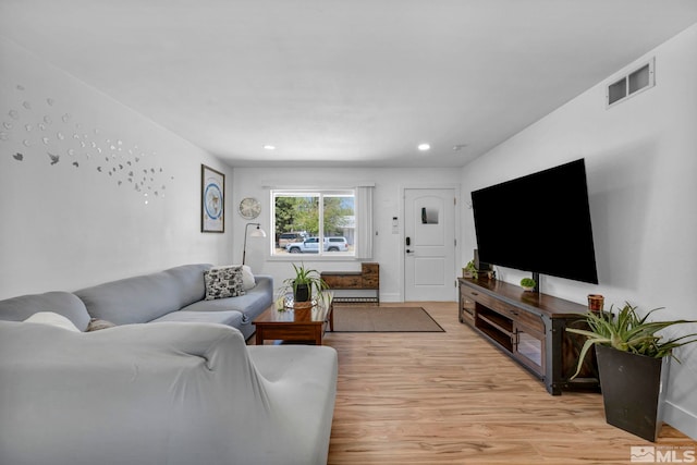 living room with light wood finished floors and recessed lighting