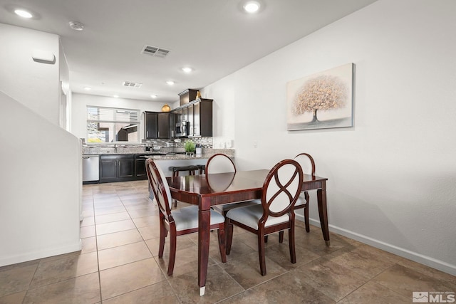 dining room featuring baseboards, light tile patterned floors, and recessed lighting
