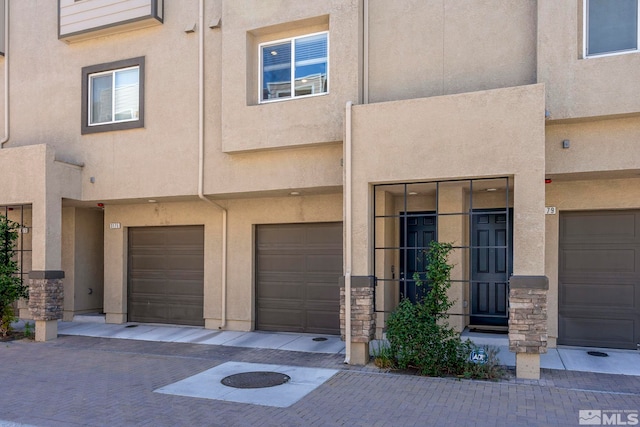 view of front of house with stucco siding and an attached garage